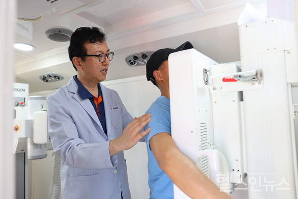 대한결핵협회결핵검진팀이보이사비축제에참가한외국인근로자에게결핵검진을위한흉부X-선영상을촬영하고있다.