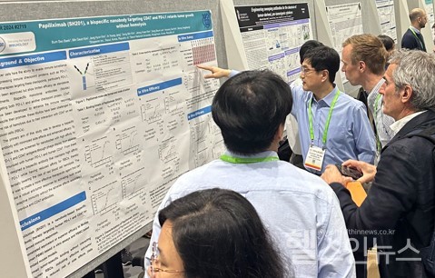 샤페론김형태연구소장이2024년AACR학회샤페론포스터앞에서참석한연구자들에게파필리시맙을설명중이다.