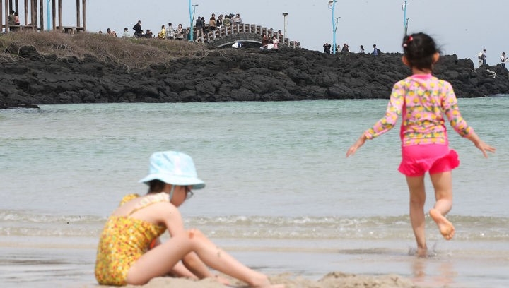 때 이른 더위가 찾아온 지난 14일 오전 제주 함덕해수욕장 해변을 찾은 관광객들이 물놀이와 바닷바람을 쐬며 즐거운 시간을 보내고 있다.