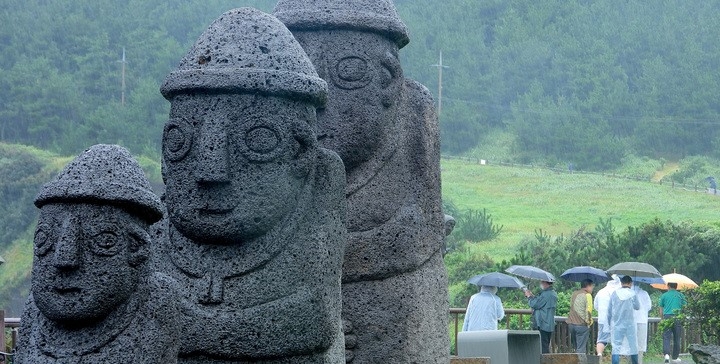 제주 서귀포시 대정읍 송악산에 우산을 쓴 관광객들이 걸어가고 있다.