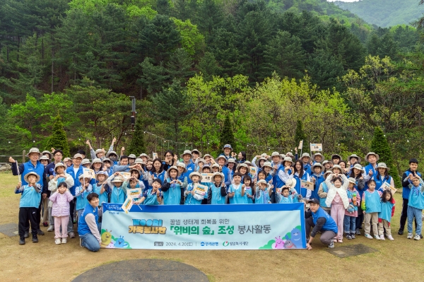 WOORI 가족 봉사단이 ‘위비의 숲 조성’ 봉사활동에 참여해 기념사진을 촬영하고 있다. / 사진=우리은행 제공