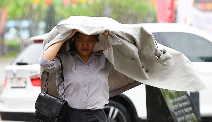 수요일인 24일은 전국이 대체로 흐린 가운데 대부분 지역에 비가 오겠다. 대기 불안정으로 싸락우박이 떨어지는 곳도 있겠다. 사진은 비가 내리던 지난 15일 서울 중구 세종대로에서 한 시민이 외투를 머리에 쓰고 출근하는 모습. 