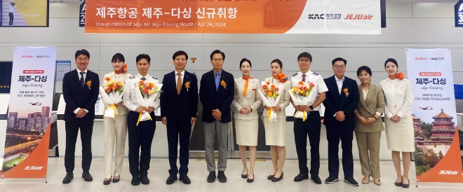 신규 취항편 승무원들과 홍준모 제주항공 안전보안본부장(왼쪽에서 네 번째), 김복근 한국공항공사 제주공항장(왼쪽에서 다섯 번째), 한상수 제주항공 제주본사운영단장(오른쪽에서 세 번째) 등 내·외빈들이 기념촬영을 하고있다. / 사진=제주항공 제공