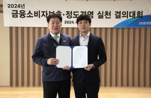 김성한 대표이사(왼쪽)와 DGB생명 임직원 대표가 금융소비자보호 준수 서약서 선창 후 기념사진 촬영을 하고 있다