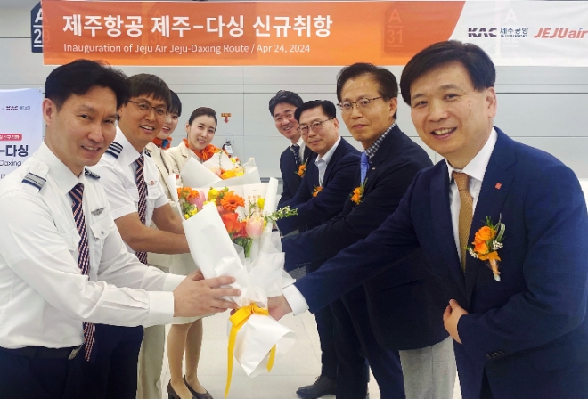제주항공은 주 4회(월·수·금·일) 일정으로 제주-베이징 다싱 노선의 운항을 시작한다고 24일 밝혔다. 사진은 이날 오전 제주국제공항에서 진행된 제주항공 제주-베이징 다싱 노선 신규취항식에 참석한 (우측 맨 앞)홍준모 제주항공 안전보안본부장 등 관계자들이 승무원들에게 꽃다발을 전달하는 모습. (사진 = 제주항공 제공)