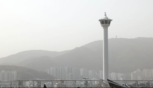 황사의 유입으로 부산 16개 구·군 모든 지역에 이틀째 '미세먼지(PM-10) 경보' 등이 발령된 18일 부산 중구 롯데백화점 광복점 옥상 전망대를 찾은 시민이 뿌옇게 변한 도심을 바라보고 있다.