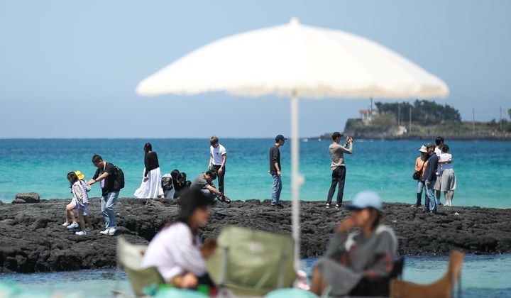 맑은 날씨를 보인 25일 오후 제주시 한림읍 협재해수욕장을 찾은 관광객들이 시원한 바닷바람을 쐬며 즐거운 시간을 보내고 있다.