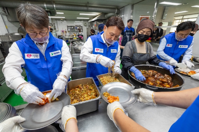 HD현대1%나눔재단은 30일 전북 군산 대명동에 위치한 ‘군산경로식당’에서 ‘행복한끼 13호점’ 개소식을 진행했다고 밝혔다. 사진은 HD현대1%나눔재단의 ‘행복한끼 13호점’ 개소식 참석자들이 배식 봉사활동을 실시하고 있는 모습. (왼쪽부터) 금석호 HD현대1%나눔재단 사무국장, 두번째 강임준 군산시장, 네번째 신영대 국회의원. (사진 = HD현대1%나눔재단 제공)