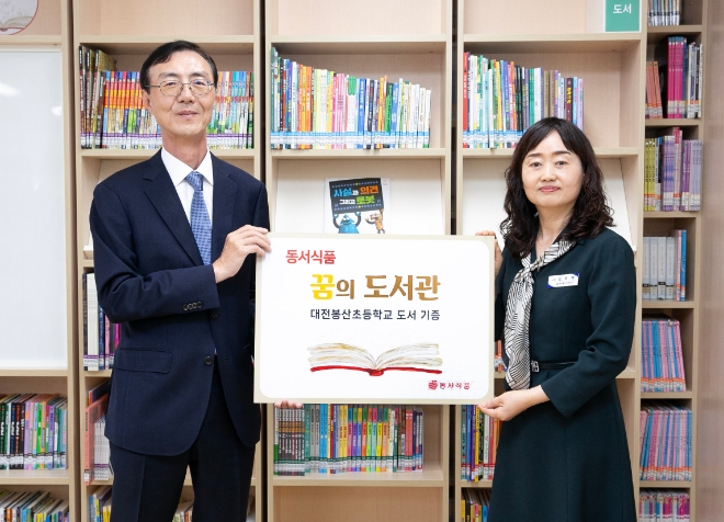 최상인 동서식품 홍보상무(왼쪽)와 김미애 대전봉산초 교장이 기증식에서 기념 사진을 촬영하고 있다. / 사진=동서식품 제공
