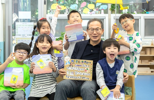 사진=KB금융그룹 양종희 회장(앞줄 왼쪽에서 세번째)이 어린이날을 맞아 KB여의도직장어린이집 어린이들에게 선물을 건네고 함께 기념촬영을 하고 있다.