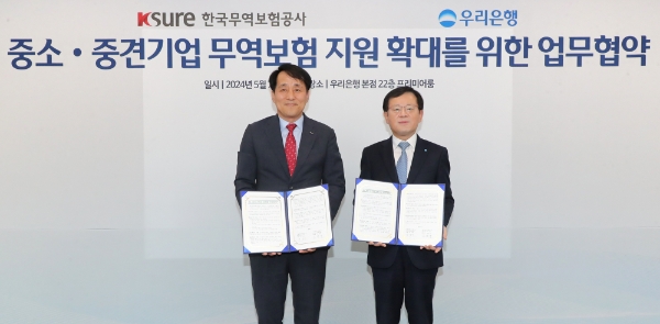 사진=조병규 은행장(오른쪽)과 한국무역보험공사 장영진 사장이 협약식에서 기념사진을 촬영하고 있다.