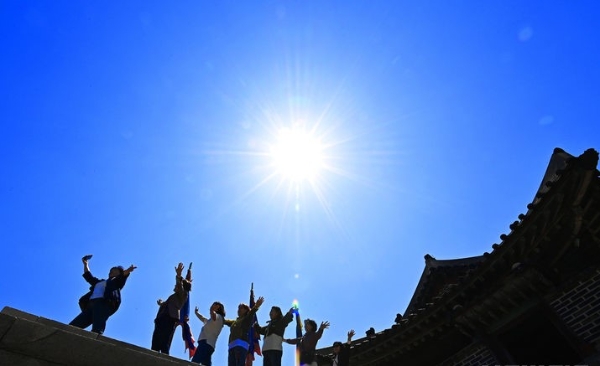 맑은 날씨를 보인 8일 경기도 수원시 팔달구 세계문화유산 수원화성 창룡문에서 산책 나온 시민들이 따스한 봄 햇살을 받으며 추억을 남기고 있다.