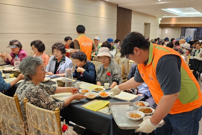 어버이날 맞이 경로잔치에서 현대건설 임직원들이 자원봉사자로 참여해 배식 봉사를 하고 있다.