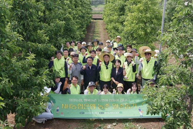 10일 농협은행 임직원들이 사과 재배농가를 찾아 일손돕기에 나섰다. 이석용 은행장(둘째줄 가운데)과 임직원 봉사단원들이 기념촬영을 하고 있다.