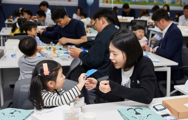 사진=SBI저축은행이 개최한 ‘회사 다녀오겠습니다’ 행사에서 임직원과 자녀가 서로 명함을 교환하고 있다.