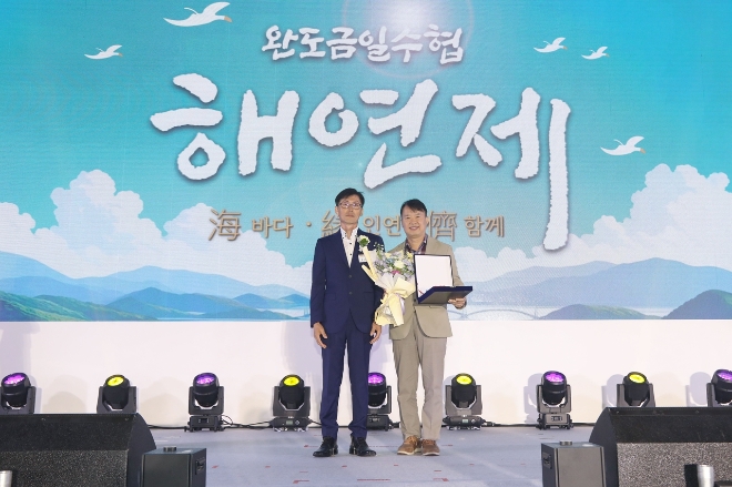 지난달 30일 완도금일수협 해연제에서 손근학 농심 ESG경영팀장(오른쪽)이 곽상운 금일어촌계장 단장으로부터 공로패를 수상하고 있다. / 사진=농심 제공