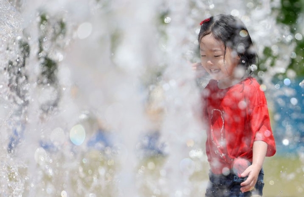 무더운 날씨를 보인 지난 19일 서울 중구 서울광장 내 분수대에서 한 어린이가 물놀이를 즐기는 모습.