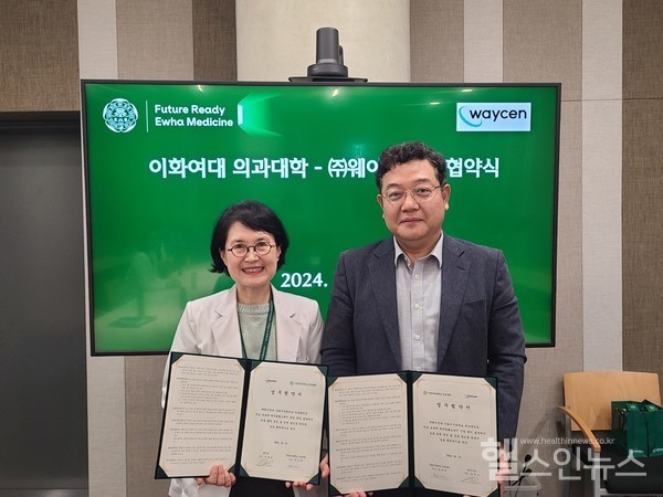 이화여자대학교하은희의과대학장과웨이센김경남대표가협약서를들고포즈를취하고있다.