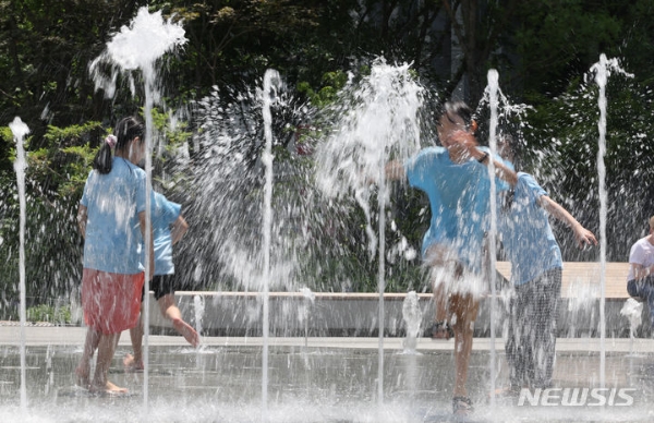 초여름 날씨는 보이는 23일 서울 종로구 광화문 광장 분수대에서 학생들이 더위를 식히고 있다.