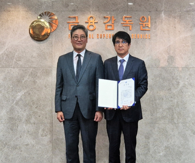 민왕일 현대백화점 경영지원본부 부사장(오른쪽)이 김정태 금융감독원 공시조사 부원장보와 기념 촬영하고 있다. / 사진=현대백화점 제공