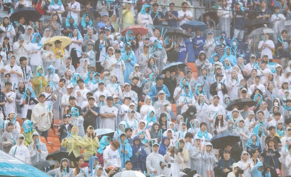 지난 26일 오후 서울 송파구 잠실야구장에서 열린 프로야구 2024 KBO리그 NC 다이노스와 LG 트윈스의 경기를 찾은 관중들이 우비와 우산을 쓰고 경기를 관람하는 모습.