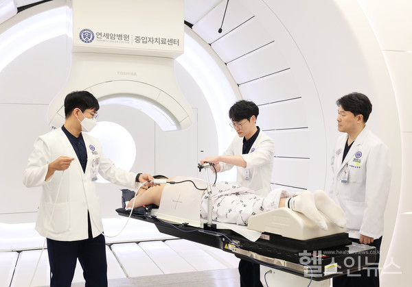 연세암병원금웅섭교수와의료진이정확한치료를위해장비를조정하고있다.