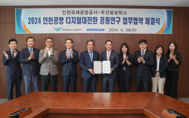 이학재 공사 사장(왼쪽 다섯 번째)이 박인원 두산로보틱스 사장(오른쪽 다섯 번째)와 협약 체결 후 양측 관계자들과 기념촬영을 하고 있다. / 사진=인천공항공사 제공