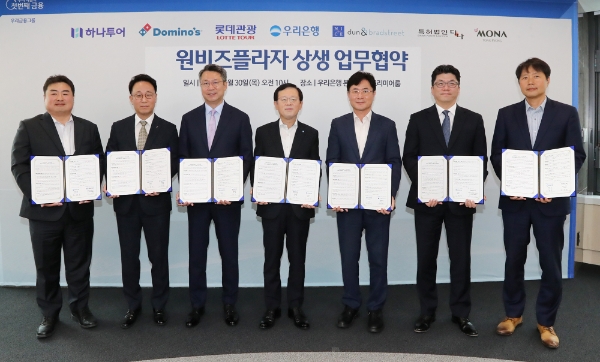 우리은행이 서울 중구 소재 우리은행 본점에서 원비즈플라자 상생 업무협약식을 진행했다. (왼쪽부터) 하나투어 이대훈 상무, 도미노피자 김영훈 사장, 롯데관광 백현 대표이사, 우리은행 조병규 은행장, 나이스디앤비 오유근 대표이사, 모나용평 김진수 부사장, 특허법인다나 진희동 대표 변리사가 협약식 이후 기념사진을 촬영하고 있다. / 사진=우리은행 제공