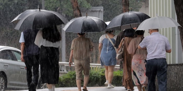 소나기가 내렸다 그치기를 반복한 22일 오후 명동역 인근에서 사람들이 우산을 쓰고 이동하고 있다.