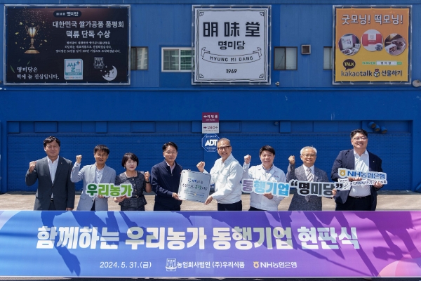 31일 평택 소재 우리식품 본사에서 농협은행 이석용 은행장(왼쪽 네 번째)과 우리식품 이상준 대표이사(왼쪽 다섯 번째)를 비롯한 양사 임직원들이 현판식을 갖고 기념촬영을 하고 있다. / 사진=NH농협은행 제공