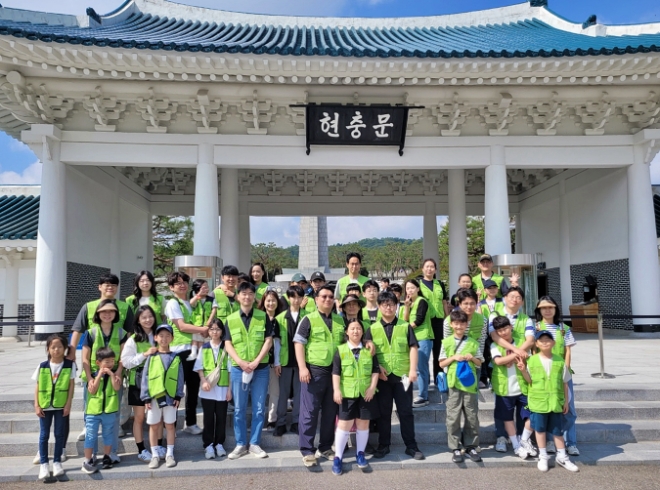 현대엔지니어링 임직원 및 임직원 가족이 국립서울현충원에서 묘역 정화 봉사활동을 한 뒤, 기념촬영을 하고 있다. / 사진=현대엔지니어링 제공