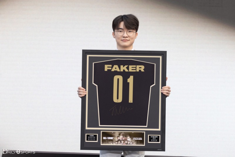 '전설의 전당' 1호 헌액을 기념하는 등번호 1번의 유니폼을 들고 포즈를 취한 '페이커' 이상혁.