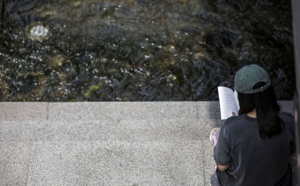 낮 최고기온이 35도로 더운 날씨를 보인 지난 14일 서울 중구 청계천을 찾은 시민이 그늘에서 책을 읽고 있다.