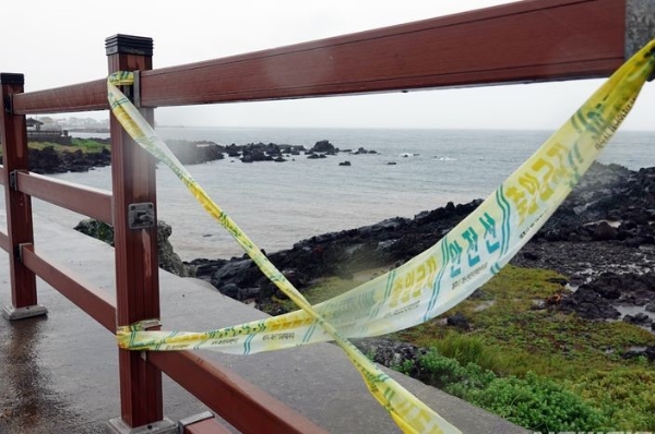 시간당 30~50㎜의 강한 비가 내리고 있는 22일 오후 제주시 이호동 해안도로에서 파손된 난간에 접근금지 테이프가 붙어져 있다.