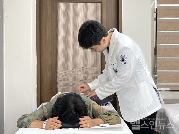 자생한방병원의료진이진료소를방문한어르신에게침치료를진행하고있다.