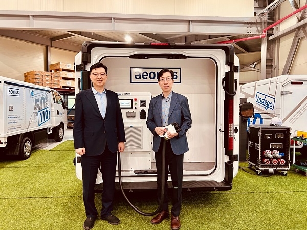 사진=이훈 ㈜에바 대표와 허은 이온어스㈜ 대표가 신형 전기차 이동방문차량 앞에서 업무협약서을 체결했다. 제공=이온어스㈜