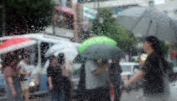 장맛비가 내리는 지난 6월 26일 부산 남구의 한 횡단보도에서 시민들이 우산을 쓴 채 발걸음을 재촉하고 있다.