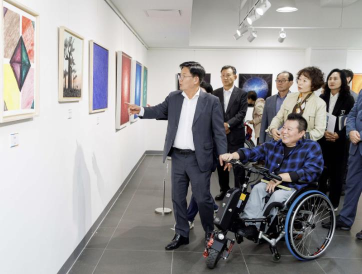 지난해 마포장애인종합복지관에서 예술로 떠나는 여행 전시회가 열려 박강수 구청장이 작품을 관람하고 있다.