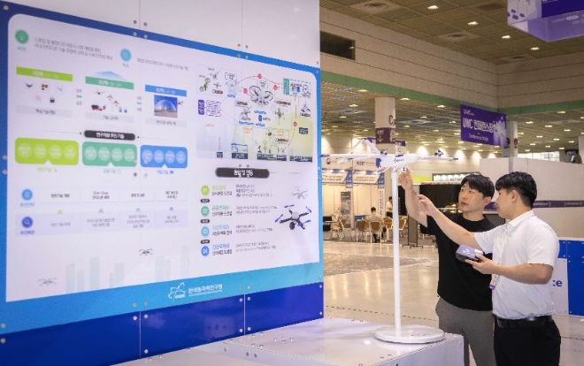 SK텔레콤은 원자력발전소나 공항 등 국가 주요 기반시설을 위협하는 불법 드론에 대응하기 위한 통신·AI 통합 모듈을 개발했다고 18일 밝혔다.사진은 서울 코엑스에서 19일까지 열리는 ‘무인이동체 산업엑스포 2024’에서 SKT와 원자력연구소 관계자가 불법 드론 대응 체계에 대해 대화하는 모습