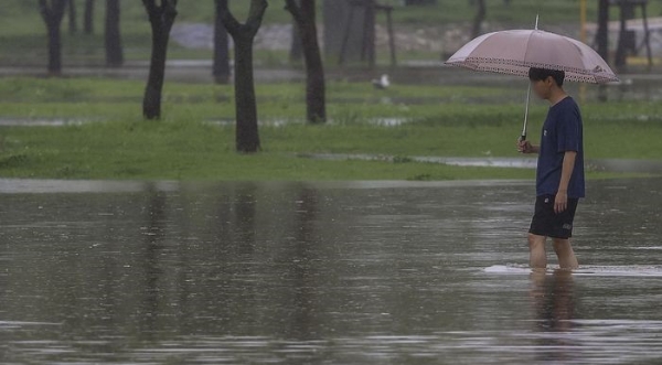 연일 이어진 집중호우로 물이 불어나 서울 서초구 잠수교가 전면통제된 가운데 18일 서울 서초구 반포한강공원에서 한 시민이 공원을 빠져나오고 있다.