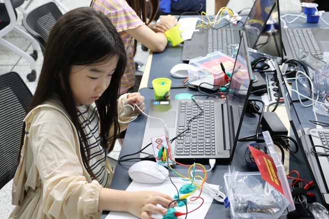 'Let’s PLAY 코딩!'에 참여한 초등학교 저학년 웹젠 임직원 자녀가 '메이키메이키'를 활용한 악기 연주를 하고 있다. 사진 제공 : 웹젠