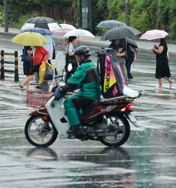 비가 내리는 22일 서울 마포구 아현역 교차로에서 시민들이 우산을 쓰고 지나가고 있다.