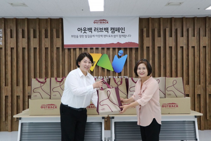 박금석 아웃백 천안펜타포트점 점주(왼쪽)와 문명희 천안시종합사회복지관 관장이 기념사진을 촬영하고 있다. / 사진=아웃백 제공