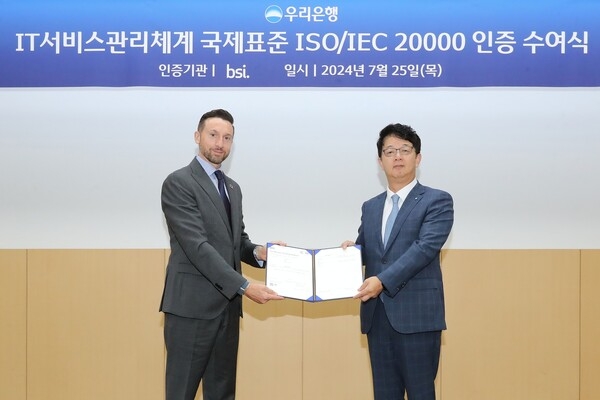 우리금융디지털타워 우리금융홀에서 우리은행 조한래 부행장(오른쪽)과 BSI그룹 보증서비스대표(Assurance Service President) 해롤드 프래달(Harold Pradal)이 ISO 20000 인증 수여식에 참석해 기념촬영을 하고 있다. / 사진=우리은행 제공