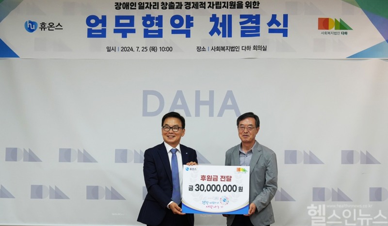 휴온스가 지난 25일 사회복지법인 다하와 장애인 카페 설치를 위한 업무협약을 체결했다고 26일 밝혔다. 송수영 휴온스 대표(왼쪽) 와 최종인 다하 대표(오른쪽)가 업무협약 체결 후 사진을 촬영하고 있다. (휴온스 제공)