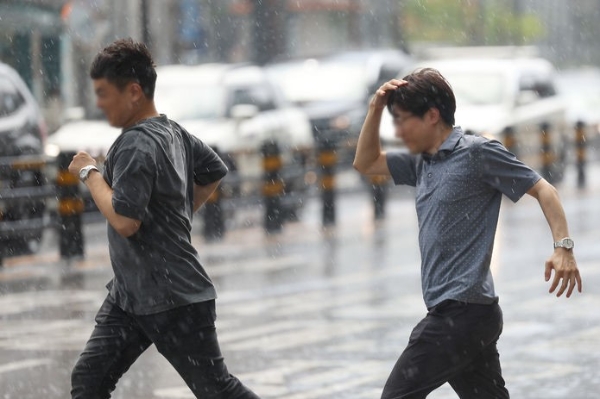 강한 소나기가 내린 지난 26일 오후 서울 중구 충무로역 사거리에서 시민들이 비를 맞으며 발걸음을 재촉하고 있다.