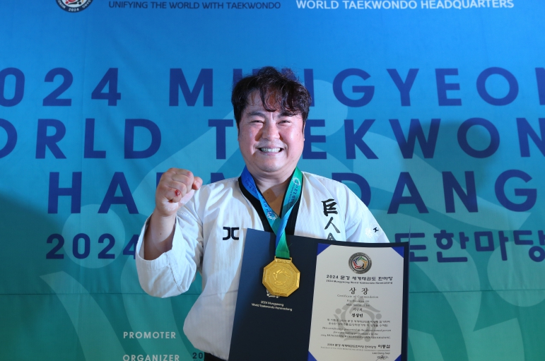 사진=주먹격파 시니어 Ⅲ 우승자인 정상민 사범이 메달과 상장을 받은 뒤 주먹을 불끈쥐며 기념사진 촬영을 했다.