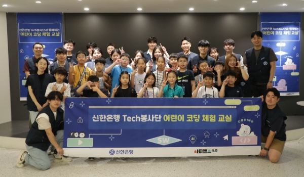 지난 27일 서울시 중구 소재 명동 익스페이스에서 ‘어린이 코딩 체험 교실’을 진행하고 ‘Tech 봉사단’ 직원들이 참여 학생들과 기념촬영하는 모습. / 사진=신한은행 제공