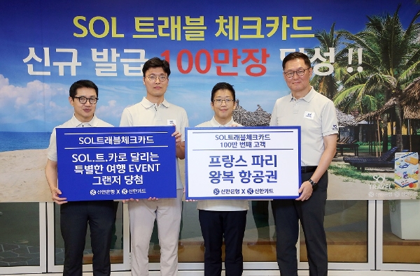 지난 29일 신한은행 본점에서 진행된 ‘신한 SOL트래블 체크카드’ 발급 100만장 달성 기념행사에서 신한은행 이해창 외환본부장(오른쪽), 신한카드 장재영 멤버십본부장(왼쪽)이 100만번째 고객(오른쪽 두번째)및 ‘SOL.트.카로 달리는 특별한 여행 이벤트’ 당첨 고객(오른쪽 세번째)과 기념촬영하는 모습. / 사진=신한은행 제공