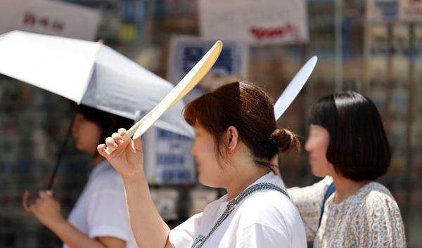 폭염이 연일 계속된 지난 30일 대구 중구 동성로에서 시민들이 부채로 햇빛을 가린 채 이동하고 있다.